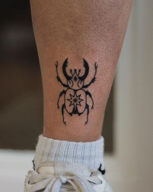 Get a stunning blackwork beetle tattoo on your lower leg by talented artist Kaśka. Unique and eye-catching design!