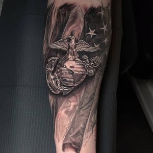 Get a bold blackwork forearm tattoo featuring an eagle, anchor, and flag in Chicago, US. Illustrative and striking design.