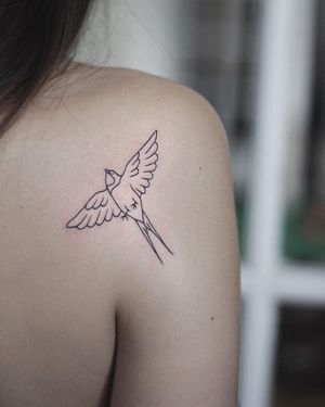 Elegant bird tattoo on the shoulder in fine line style by the talented artist Kaśka.