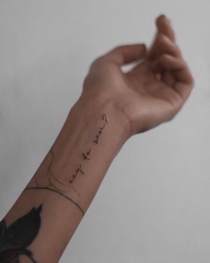 Elegantly crafted small lettering quote tattoo by Adrian Mokijewski on the forearm, perfect for minimalistic tattoo lovers