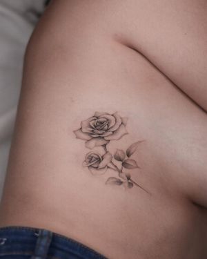 Adrian Mokijewski's illustrative black and gray flower tattoo delicately inked on the ribs.