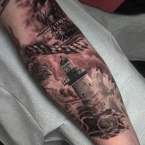Get a stunning illustrative tattoo of a lighthouse, ship, and rope on your forearm in Chicago. Realism style. Book now!