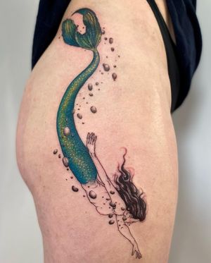 Elegant and intricate illustrative mermaid design on upper leg, expertly done by tattoo artist Magdalena Sawicka.