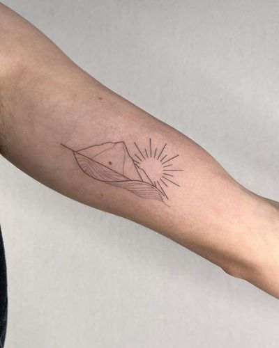 A stunning fine line illustrative tattoo on the forearm featuring a sun, mountain, and waves, by Dominika Gajewska.