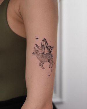 Impressive black and gray illustrative design featuring a majestic deer, delicate butterfly, and elegant wings on the upper arm by Adrian Mokijewski.