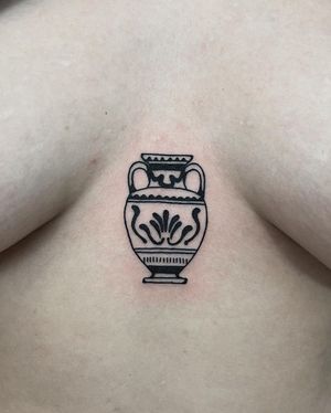 Unique blackwork chest tattoo featuring a beautifully detailed vase design by Kaśka.