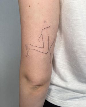 Illustrative upper arm tattoo by Dominika Gajewska featuring a woman drinking from a glass.