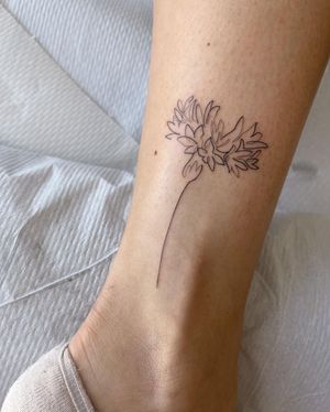 Illustrative flower tattoo by Dominika Gajewska, delicately inked on the ankle for a subtle yet stunning look.