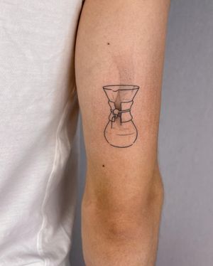 Fine line coffee tattoo on upper arm by Dominika Gajewska, perfect for coffee lovers