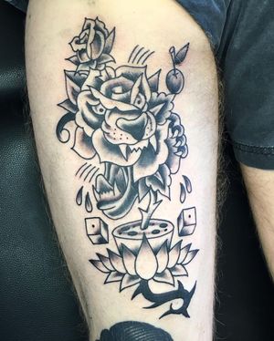 Illustrative upper leg tattoo featuring a fierce tiger, delicate flowers, lotus, dice, and cherry by artist Phil Botha.