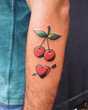 Get inked by Phil Botha with a classic illustrative design featuring a heart, arrow, and cherry motif on your forearm.