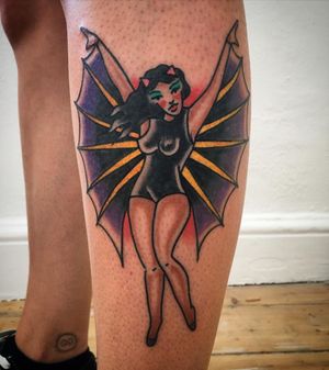 Capture the dark allure of a vampire woman with wings and cape in this traditional lower leg tattoo by Phil Botha.