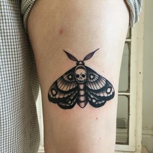 Unique blackwork design by Natalie Lucia featuring a mystical moth and skull motif on the upper arm.