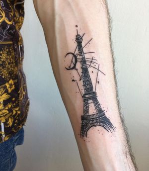 Illustrative blackwork tattoo featuring the iconic Eiffel Tower under a crescent moon, beautifully crafted by artist Natalie Lucia on the forearm.