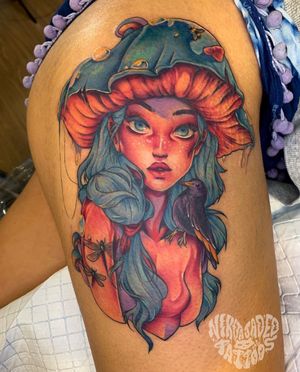 Vibrant upper leg tattoo featuring a girl, bird, dragonfly, and mushroom, beautifully designed by Nikita Jade Morgan.