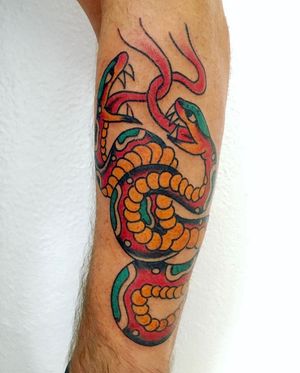 Captivating forearm tattoo by Phil Botha featuring a stunning illustrative traditional snake motif.
