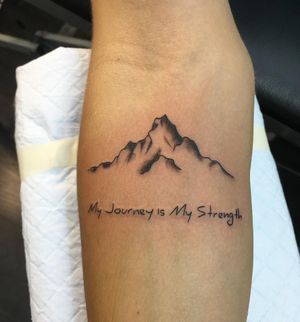 Elegant fine line mountain tattoo with small lettering quote by Natalie Lucia on the forearm.