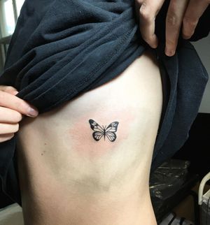 Elegant and intricate blackwork butterfly design on the ribs, expertly done by tattoo artist Natalie Lucia.