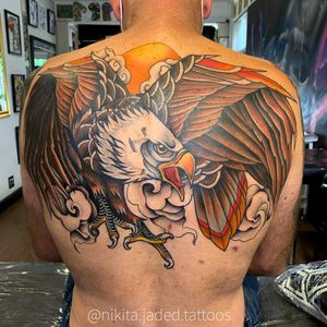 Get a stunning illustrative traditional tattoo featuring a sun, eagle, and cloud by talented artist Nikita Jade Morgan.
