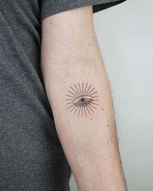 Unique forearm tattoo featuring a detailed eye in a fine line illustrative style, created by artist Dawid Szubert.