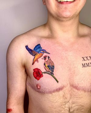 This stunning chest tattoo by Lou. W features a beautifully detailed bird and flower in a realistic and watercolor style.