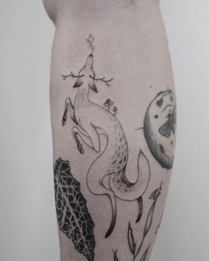 Experience the detailed beauty of Lena Dabska's blackwork illustrative tattoo featuring a fox and horns on your lower leg.