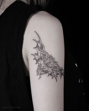Get a striking blackwork tattoo of a devil with wings and monster elements by Mara on your upper arm.