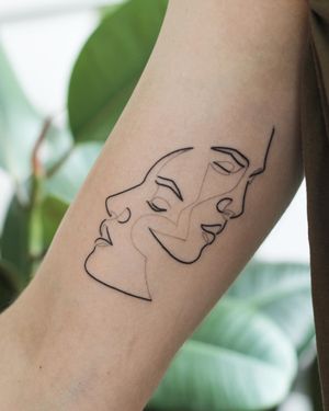 A stunning blackwork and fine line tattoo on the upper arm featuring a beautiful illustration of a man and woman, done by the talented artist Dominika Gajewska.