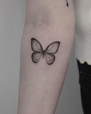 Explore the intricate beauty of Martyna Śliwka's blackwork butterfly design on your forearm.