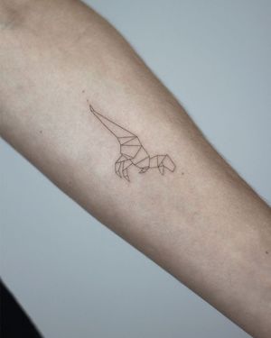 Get a unique and detailed dino tattoo by artist Dawid Szubert, showcasing fine line and geometric elements on your forearm.
