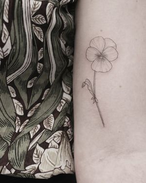 Elegant and delicate flower design on the upper arm, expertly created by talented artist Martyna Śliwka.