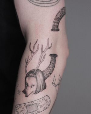 Elegant blackwork tattoo by Lena Dabska featuring an illustrative fox with horns, beautifully executed in fine line style