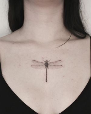 Discover the beauty of a black and gray illustrative dragonfly tattoo by Martyna Śliwka. Stunning chest piece!