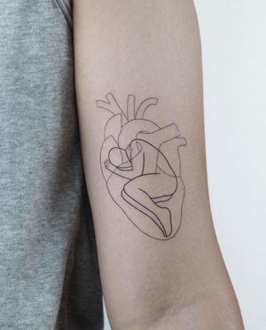 Explore the intricate details of this illustrative upper arm tattoo featuring a heart, pattern, and man by artist Dawid Szubert.