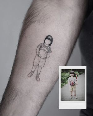 Unique illustrative design of a kid playing with a ball, expertly executed by tattoo artist Martyna Śliwka on the forearm.