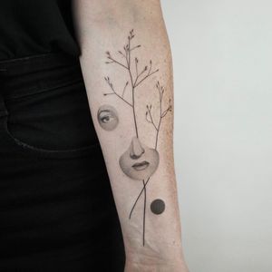 Fine line blackwork forearm tattoo featuring a beautiful woman surrounded by flowers and sprigs, done by Dawid Szubert.
