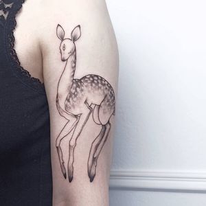 Elegant blackwork deer design on upper arm, expertly executed with fine line details by talented artist Lena Dabska.