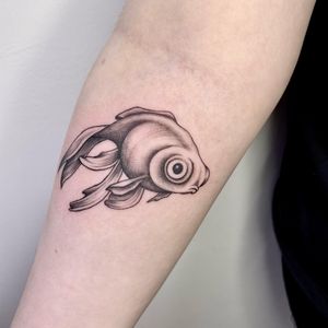 Black and gray illustrative fish and sealife tattoo on forearm by Lou. W.