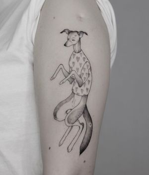 Get a unique blackwork tattoo of a dog and heart on your upper arm with delicate illustrative details by Lena Dabska.