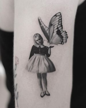 Beautiful blackwork tattoo of a butterfly and girl on upper arm by Martyna Śliwka.