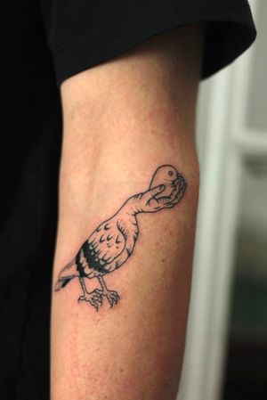 Unique blackwork design by Kaśka on upper arm featuring a bird and hand motif.