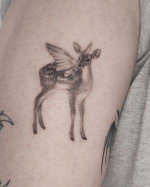 Capture the elegance of a deer with wings in this black and gray upper arm tattoo by Martyna Śliwka. Embrace the mystical with this stunning design.