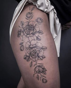 Elegant blackwork peony tattoo on upper leg, featuring intricate fine line details. Find your perfect floral design in Los Angeles!