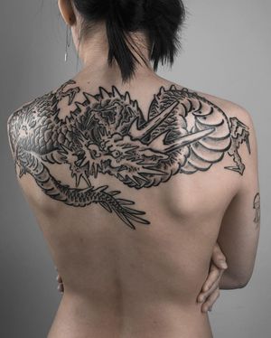 Embrace the power of the dragon with this stunning blackwork tattoo by FKM TATTOO on your upper back. The intricate Japanese illustrative style brings this mythical creature to life.