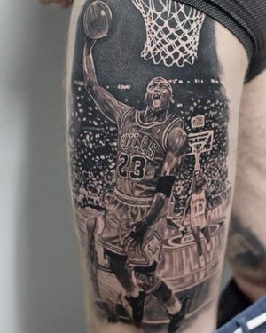 Get a realistic black and gray illustrative tattoo of Michael Jordan in his Chicago Bulls jersey on your upper leg in Long Beach, US.