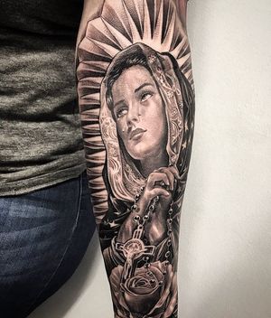 Capture the ethereal beauty of an angel and cross on your forearm in Long Beach. Expertly executed in detailed black and gray realism.