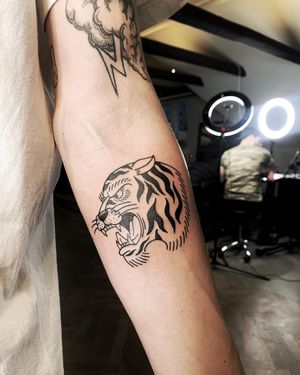 Get inked with a bold blackwork tiger design on your forearm by the talented artist Lars. Stand out with this fierce and illustrative tattoo!