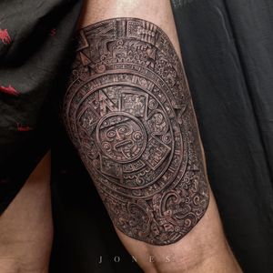 Unique blackwork design on upper arm combining tribal elements and calendar motifs by tattoo artist Jones.