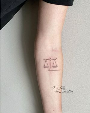 Fine line and illustrative forearm tattoo featuring intricate patterns symbolizing balance and justice.