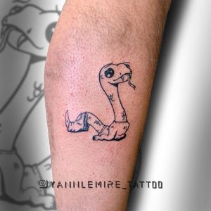Elegant blackwork snake design on lower leg, expertly executed with fine line illustrations by the talented artist Yann.